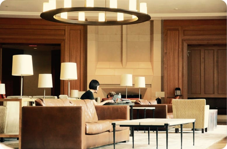 An airport lounge with armchairs and reading lamps